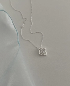 Macro shot of S925 silver four-leaf flower pendant with sparkling cubic zirconia inlay