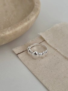 Macro shot of 925 sterling silver ring with ball relief and industrial texture on linen
