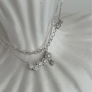 Elegant 925 sterling silver smile necklace with curved zircon clusters on white stand