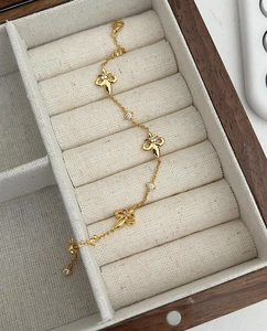 Detail of a vintage golden fleur-de-lis bracelet with crystals in a wooden jewelry box