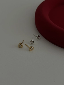 Vue détaillée des boucles d'oreilles cœur en or et argent avec zircons cubiques