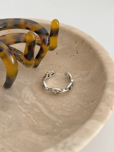 Detailed view of an S925 sterling silver anchor link ring on a textured stone tray