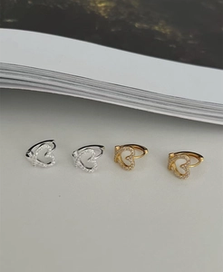 Detail of silver and gold heart hoop earrings with micro-paved crystal stones