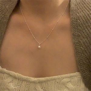 Macro detail of natural freshwater pearl pendant on a gold S925 sterling silver chain