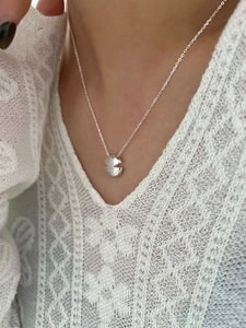 Gros plan d'un collier minimaliste en argent S925 avec pendentif rond sur mannequin