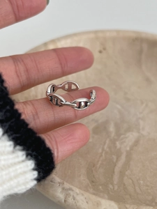 Close-up of vintage S925 sterling silver pig nose chain ring worn on a finger
