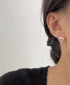 Close-up of S925 sterling silver heart earrings with pavé crystals on a model's ear