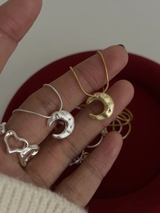 Detailed view of crescent moon pendant necklaces with heart-shaped hollow ring