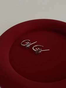 Macro detail of S925 sterling silver palm tree stud earrings with textured hoop design