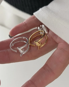 Detail of minimalist S925 silver knot rings in gold and silver finish on a finger
