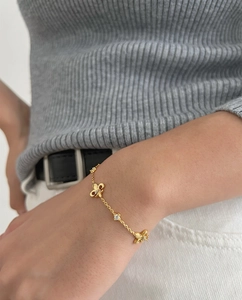 Close-up of a gold-plated bracelet with hollow butterfly charms and sparkling cubic zirconia