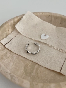 Macro detail of vintage S925 sterling silver pig nose ring on rustic burlap texture