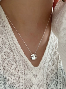 Gros plan d'un collier en argent 925 avec pendentif disque géométrique sur le cou
