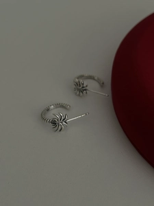 Macro detail of S925 sterling silver hoop earrings with vintage palm leaf design
