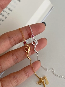 Nahaufnahme der S925 Silber Schlangenhalsketten mit roten Tropfensteinen in Gold und Silber