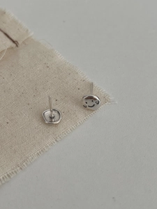 Dettaglio di orecchini a lobo smile in argento S925 con texture vintage e opaca