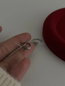 Macro detail of S925 sterling silver palm tree earrings held in a jewelry tray
