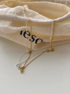 Detailed view of 925 silver teardrop pendants in gold and silver on a fabric pouch