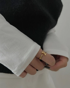 Detail view of a gold S925 sterling silver balance bar ring on a model's finger
