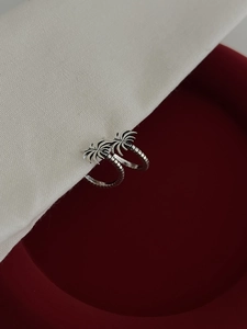 Detail of S925 sterling silver palm tree earrings with vintage textured finish on red velvet