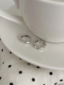 Détails macro de boucles d'oreilles créoles en argent S925 avec motifs d'étoiles