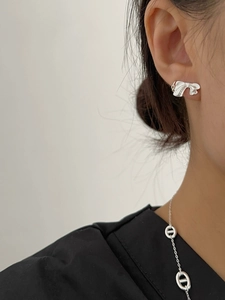 Détail de la boucle d'oreille nœud en argent et du collier sur le modèle