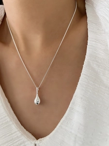 Close-up of S925 sterling silver teardrop pendant necklace worn on the collarbone