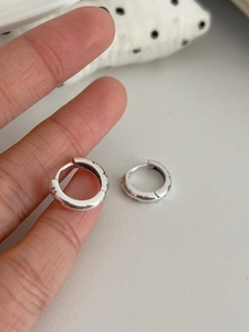 Vue macro détaillée des créoles en argent sterling S925 avec motifs d'étoiles gravés