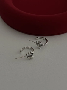 Close-up of S925 sterling silver palm leaf earrings with vintage oxidation and C-hoop design