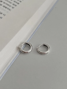 Détail de créoles en argent S925 avec étoiles gravées sur un fond de livre