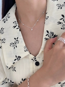 Close-up of S925 sterling silver teardrop necklace and openwork floral ring