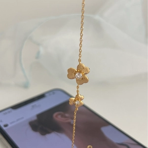 Exquisite gold clover flower necklace with matte petals and sparkling zircon center