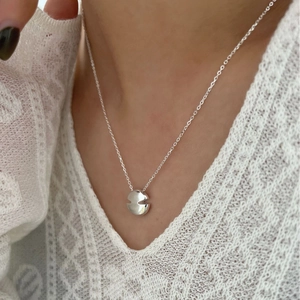 Élégant collier avec pendentif disque V en argent S925 porté par un mannequin en dentelle