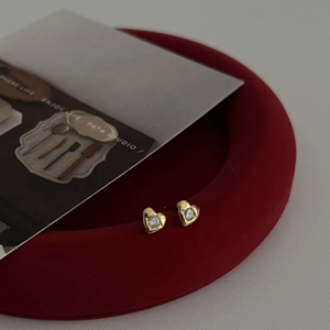 Boucles d'oreilles cœur en argent 925 avec zircon blanc sur un plateau rouge élégant