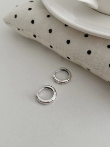 Vue détaillée de créoles en argent avec motifs d'étoiles noires gravés et finition polie