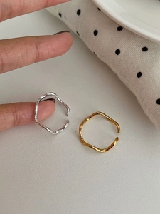 Detail of irregular textured open rings in gold and silver with handmade hammered finish