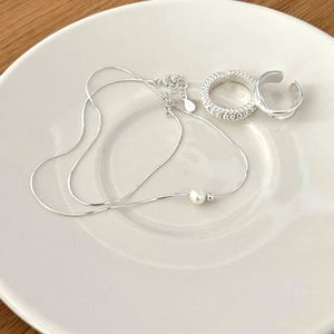 S925 silver snake chain necklace with pearl and textured rings on a white tray