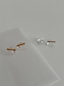 Detailed view of silver and gold minimalist bar earrings with clear stones and beads