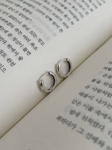 Détail de créoles en argent sterling S925 avec motifs d'étoiles gravés sur des pages