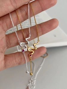 Close-up of S925 sterling silver snake necklaces with red ruby gemstone pendants
