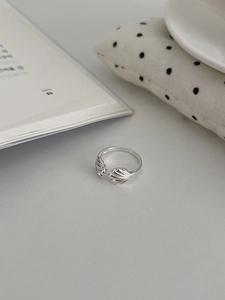 Detailed view of the wave-textured S925 silver shell ring on a minimalist background