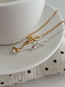 Detailed view of the red drop-shaped gemstone inlaid on a snake head pendant necklace