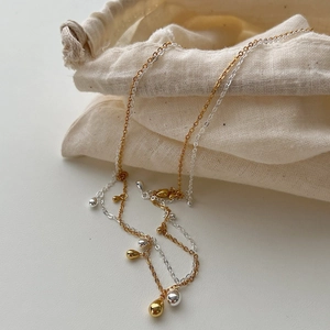 Minimalist 925 silver teardrop pendant necklaces in gold and silver on a linen pouch