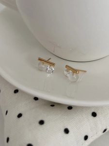 Macro detail of S925 silver gold bar stud earrings with clear round cubic zirconia