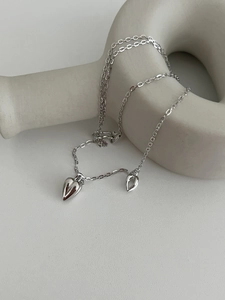 Macro detail of S925 sterling silver double heart pendant on a minimalist O-chain necklace