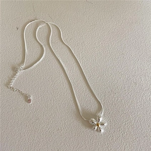 Close-up of S925 sterling silver flower pendant with snake chain and gold center