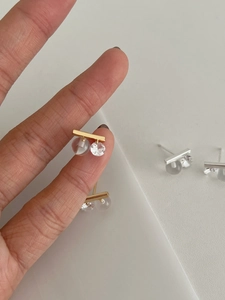 Macro detail of S925 silver bar earrings with cubic zirconia and frosted bead accents