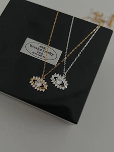 Détail de colliers œil porte-bonheur avec zircone en or et argent sur une boîte cadeau
