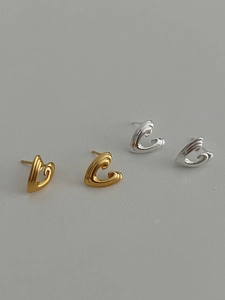 Detail of minimalist 3D curved heart studs in polished gold and silver finishes