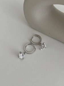 Détail de boucles d'oreilles créoles en argent avec pendentif moissanite en forme de cœur